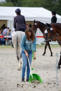 Pauline Müller sammelt die Pferdeäpfel vom Platz...