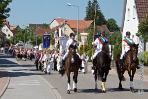 Dorothee Kohnle auf Caretina und Larissa Gösele auf Herta flankierten Rainer Abele auf Riko, der die Standarte trug. Bei strahlendem Sonnenschein zog die Prozession durch das Dorf...