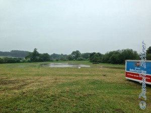 Der Abreiteplatz ist wieder ohne Begrenzungsstäbe, aber durch den starken Regen steht er jetzt unter Wasser...