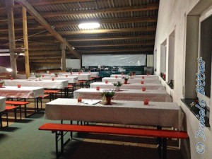Oben sind alle Tische mit Tischdecke versehen, und mit Gestecken und Kerzen geschmückt.
