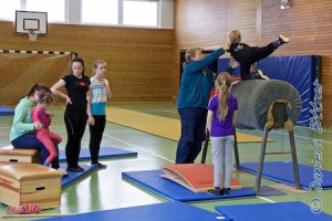 Nora Pautz mit der Lehrgangsleiterin Hannelore Leiser bei ihrer Übung, Anja und Kathrin Zappe, Katja Wilhelm und Anna-Lena Hammele sehen zu, neben dem Holzpferd steht noch Nina Hauber
