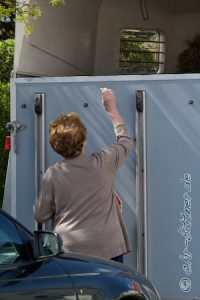 Anne Kirsch gibt jedem Pferdegespann noch den Segen mit Weihwasser auf den Weg....