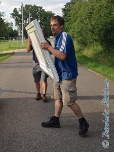 Manuel und Josef bringen eine große Tür.. Die soll oben in den Container...