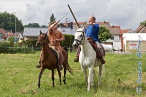 Martin auf seiner Shagya-Stute Dhana und Rolf auf dem großen Schimmel Rantanplan. Hier gibt es Schwertkämpfe zu Pferde...