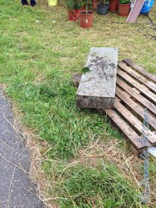 Dieses schwere Stück Stein soll unten an die Leiter hin, damit die Stufen nicht im Dreck aufliegen..